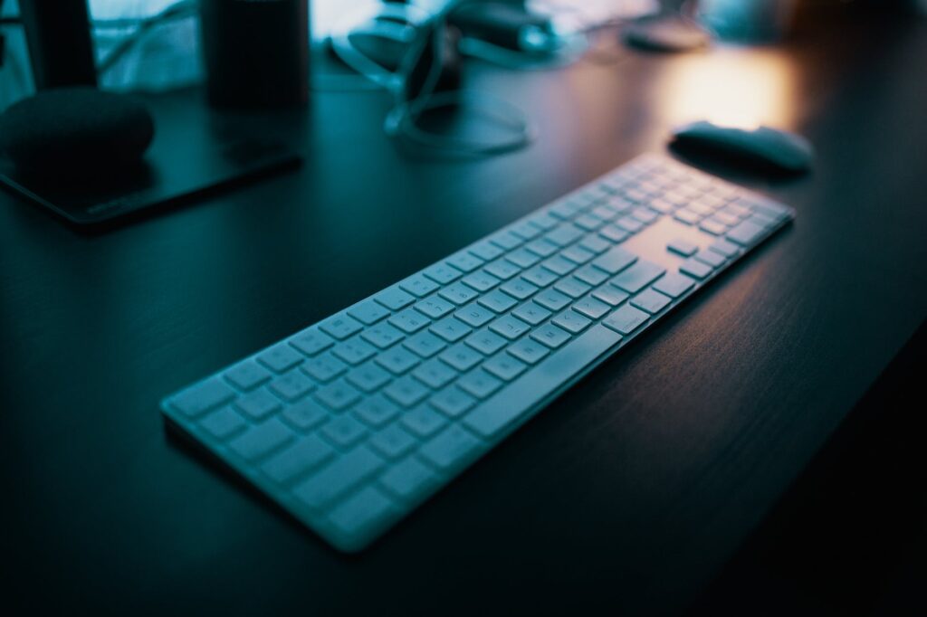 apple magic keyboard with numeric pad on table near wireless mouse Desktop vs Smartphone 