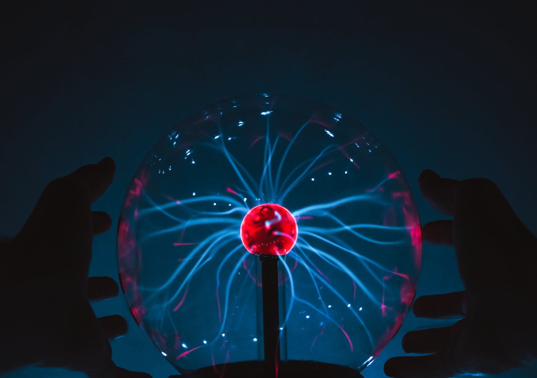 hands between a plasma ball